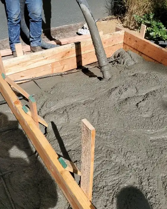A pump hose placing concrete into wood forms